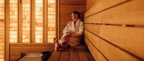 A sauna with wooden benches and a large window.