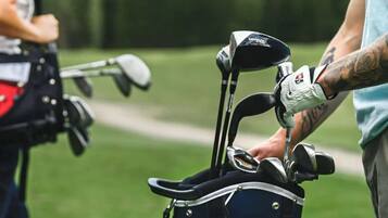 Ein Golfbag mit mehreren Schlägern und ein Golfbag mit Tragegurt.