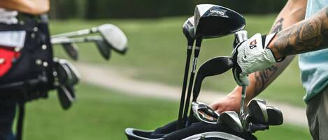 Un bolso de golf con varios palos y un bolso de golf con correa.