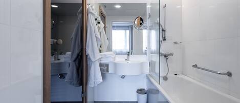 A modern bathroom with a glass shower enclosure, a white sink, and a bathtub.