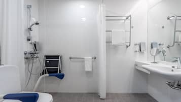 A modern bathroom with a shower, toilet, and sink.