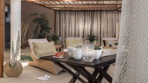 Comedor con una mesa dispuesta para dos personas, con tazas blancas, una jarra y un plato de fresas.