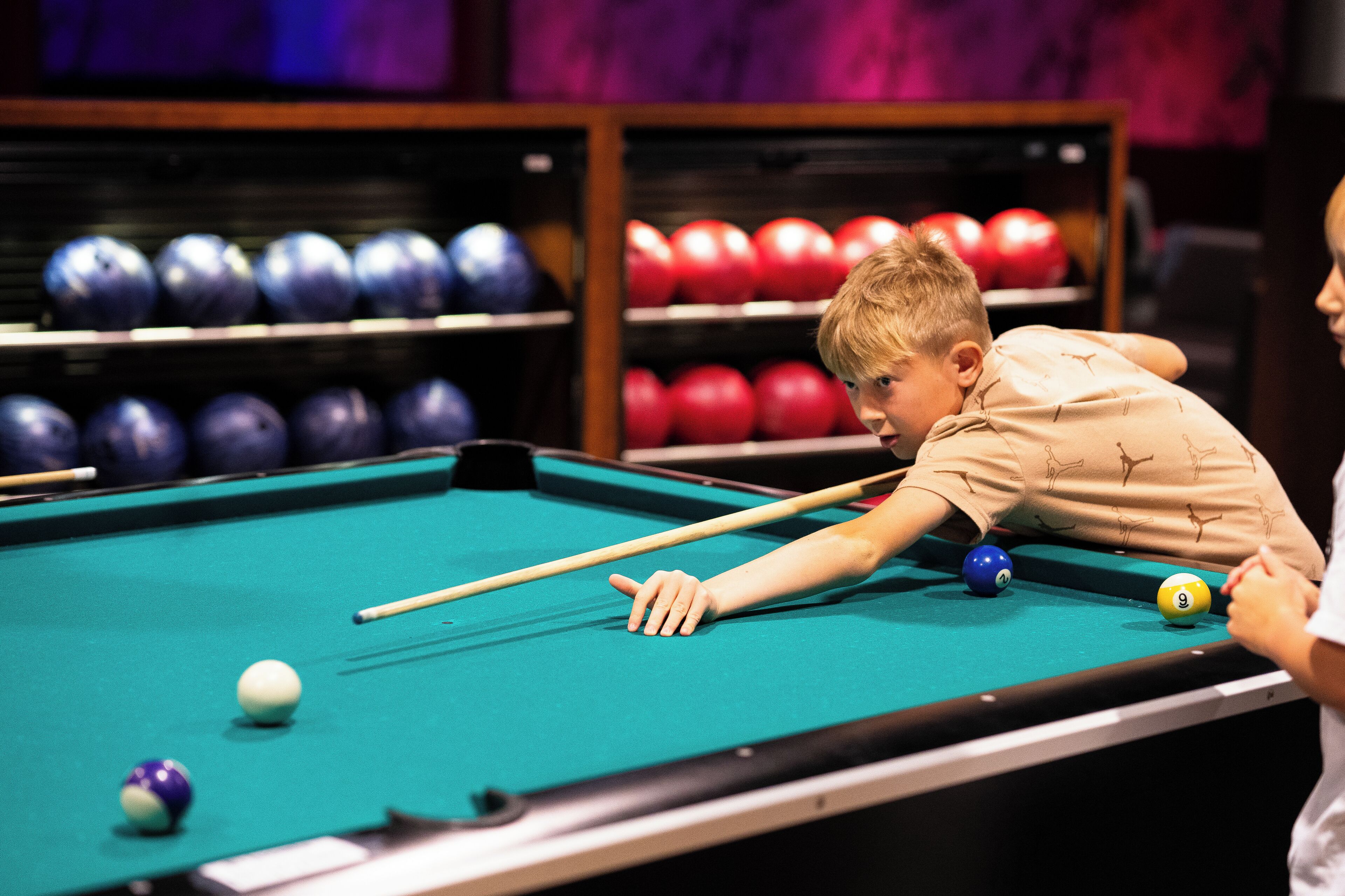 A pool table with balls and a cue stick.