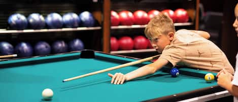 A pool table with balls and a cue stick.