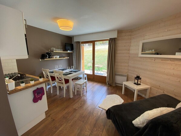 A compact room with a kitchenette, dining area, and a bed. - Modern apartment with terrace, 6 people, parking included (Châtel)