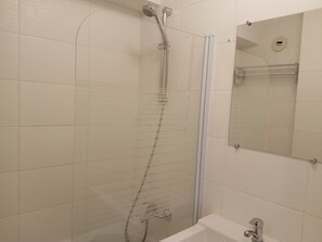 A bathroom with a glass shower enclosure, a bathtub, and a mirror above the sink. - Modern apartment with terrace, 6 people, parking included (Châtel)