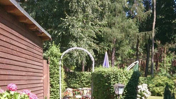 Ein Gartenweg, der zu einem hölzernen Gebäude mit einem blauen Zaun führt.
