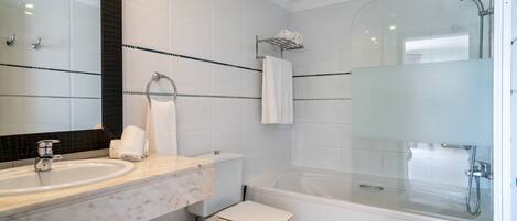 Un baño moderno con un espejo grande, un lavabo, un inodoro, una bañera y una ducha.