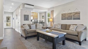 Una sala moderna con dos sofás, una mesa de centro y un ventilador de techo.