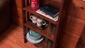 Une étagère en bois avec une télécommande, un livre et un récipient.