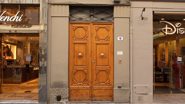 Puerta doble de madera con un diseño geométrico, un letrero con el número 9 y un escaparate con el logotipo de Disney.