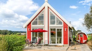 En röd byggnad med stora fönster och ett rött parasoll.