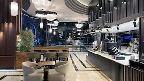 A modern interior with a bar area, seating, and a large screen displaying 'KAFES'. - The Conforium Hotel Van (Van)