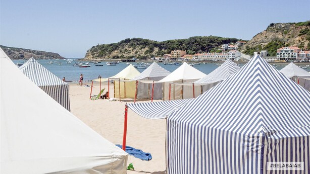 Beach tents, a sandy beach, and boats in the water. - Modern, air-conditioned family apartment with pool. 10 minute walk to beach (Salir do Porto)