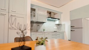 Eine moderne Küche mit weißen Schränken, einem Holzespeisetisch und einem kleinen Topf mit Pflanze.