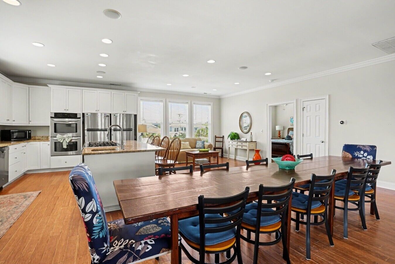 A modern kitchen with white cabinets, stainless steel appliances, and a large island.