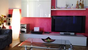 A modern living room with a flat-screen TV, a coffee maker, a printer, and a white cabinet. - Casa Benty - Entire Loft (Palermo)