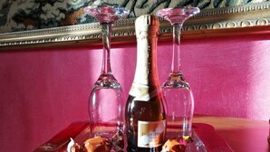 A bottle of wine on a tray with two glasses and some snacks. - Casa Benty - Entire Loft (Palermo)