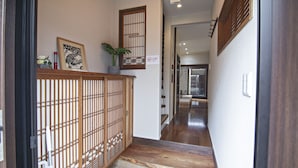 A traditional Japanese interior with a wooden gate, tatami mat flooring, and a cat-shaped doormat.