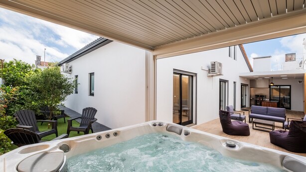 Un espace avec un bain à remous, des sièges et une vue sur le jardin.