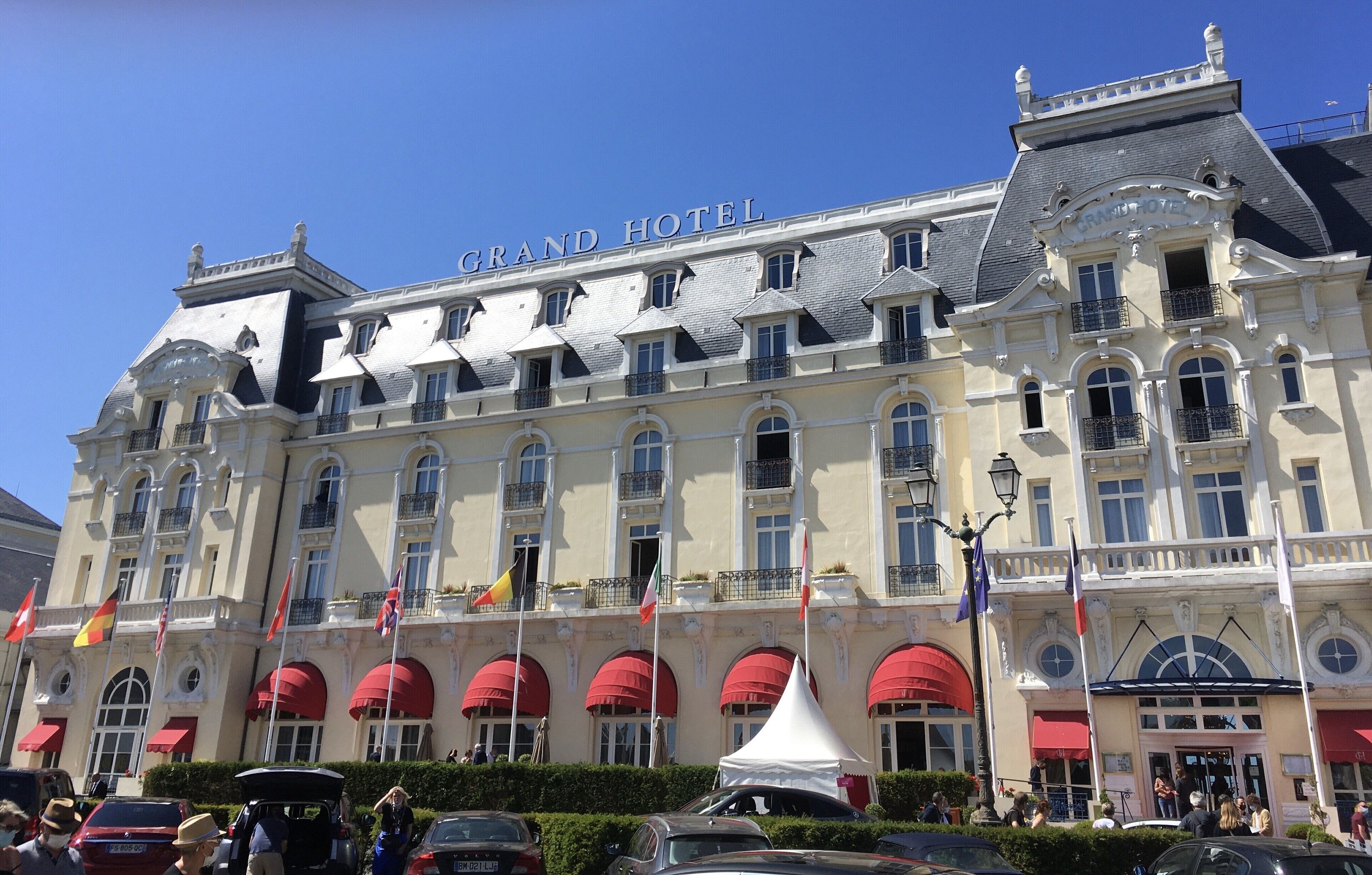 A large hotel with multiple balconies and red awnings.
