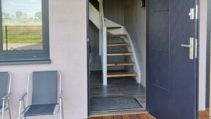 A wooden deck with a black door and a staircase leading to an upper level. - Sunny Paradise-s?oneczny Raj (Sarbinowo)
