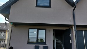 A two-story house with a balcony, a staircase leading to the second floor, and a garage door. - Sunny Paradise-s?oneczny Raj (Sarbinowo)