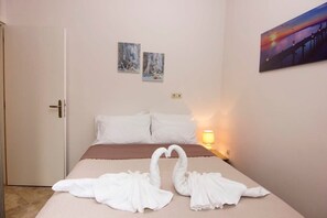 Una habitación de hotel con una cama, dos obras de arte en la pared y una lámpara.