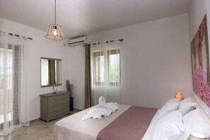 A bedroom with a bed, a dresser, a mirror, and a painting on the wall.