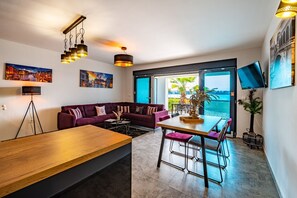 Apartamento Deluxe | Zona de estar | Televisión de pantalla plana de 42 pulgadas con canales por satélite