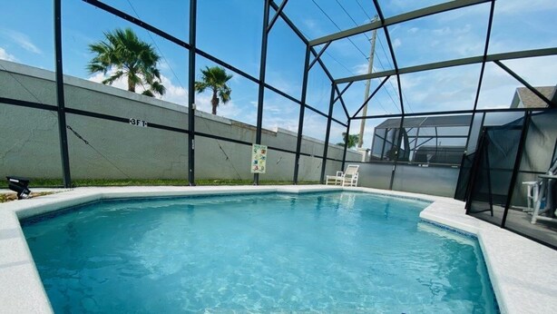 A rectangular indoor pool with clear blue water, surrounded by a white pool deck and a glass enclosure. - Southern Dunes Golf With Views! 3 Bedroom Home by RedAwning (Haines City)