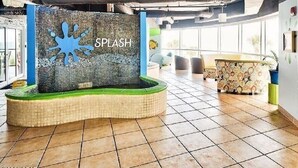 A spacious lobby with a central feature labeled 'SPLASH' and a tiled floor.
