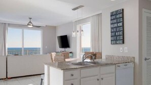 A modern kitchen with a large window and a view of the ocean.
