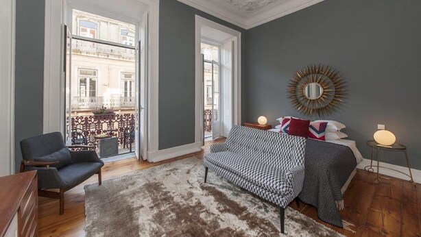 Una sala de estar moderna con un sofá, un sillón y un espejo grande.