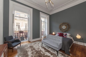 Una sala de estar moderna con un sofá, un sillón y un espejo grande.