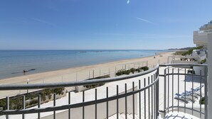 Un balcon avec vue sur une plage et la mer.