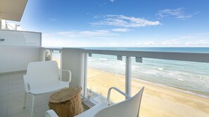 A balcony with white chairs and a wooden stump, overlooking a sandy beach and the ocean under a clear sky. - Rivazzurra C (Termoli)