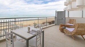 A balcony with a table and chairs, a wicker sofa, and a view of the beach and ocean. - Rivazzurra C (Termoli)