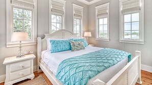 Un dormitorio con cama, mesitas de noche y ventana con persianas.