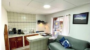 A compact living space with a kitchenette, a sofa, and a small dining area.