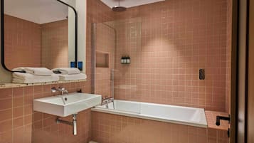 A bathroom with a sink, mirror, and shower.