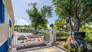 A gated entrance with a sign advertising a local event, a tree, and a digital display. - RV Camper in the heart of Key Largo (Key Largo)