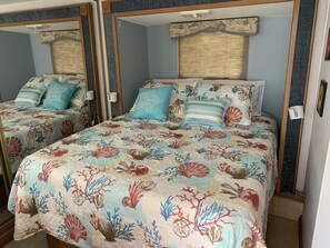 A bedroom with two beds, each with a floral bedspread and matching pillows. - RV Camper in the heart of Key Largo (Key Largo)