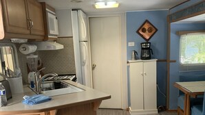 A compact kitchen with a central island, a refrigerator, a coffee maker, and a microwave. - RV Camper in the heart of Key Largo (Key Largo)