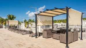 A covered outdoor seating area with wicker furniture and a canopy. - RV Camper in the heart of Key Largo (Key Largo)