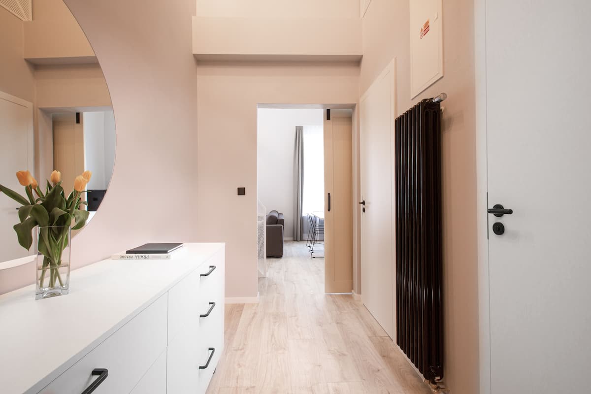 A hallway with a white counter, a black radiator, and a door leading to another room.