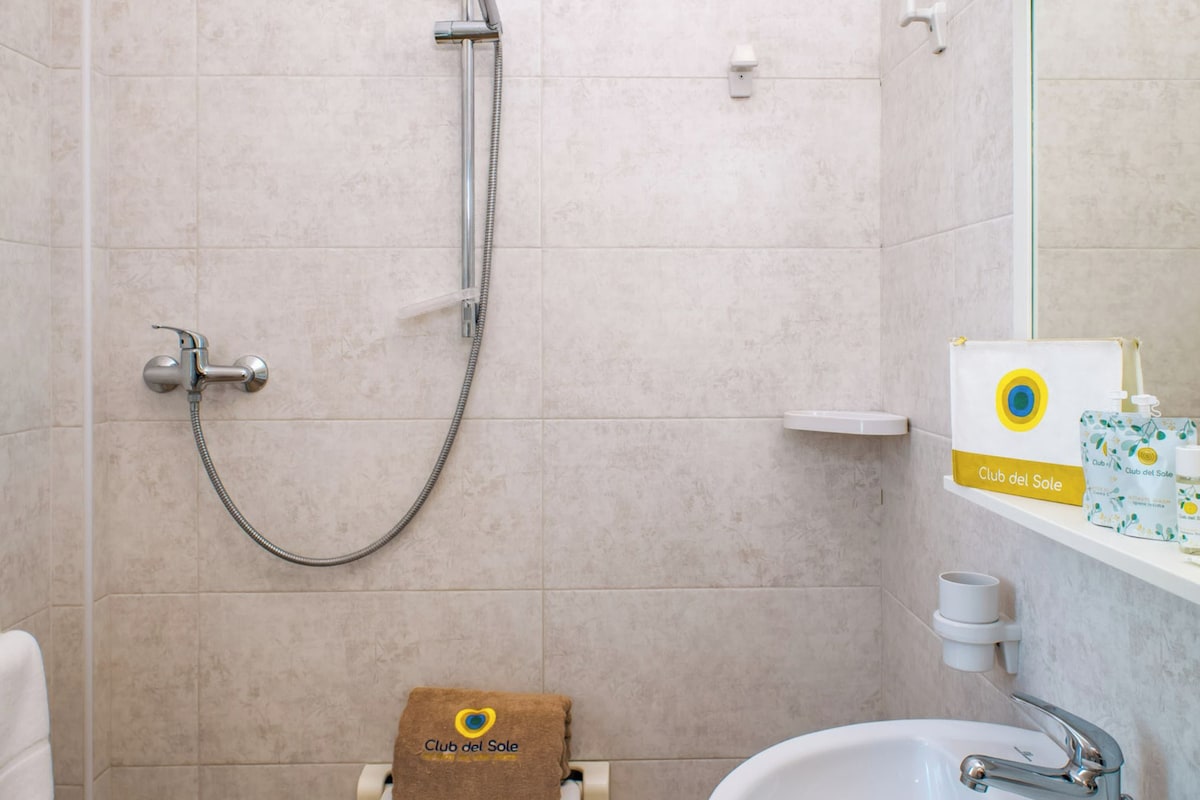 A bathroom with a shower, toilet, and sink.