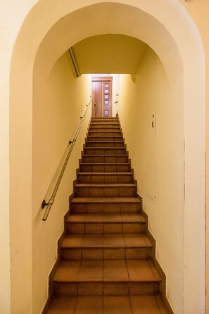 Eine Treppe mit Handlauf, die zu einer Holztür oben führt.