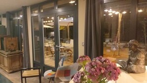A dining area with a table, chairs, and a vase of flowers.