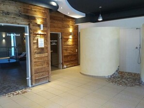 Un vestíbulo de hotel con una pared de madera, una recepción y una zona de ducha.